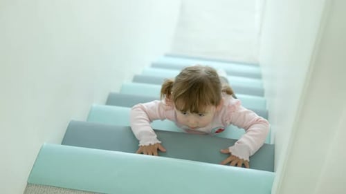 Child Crawls Up Blue Carpeted Indoor Stairs