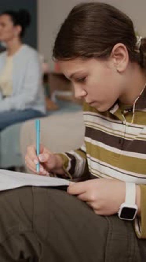 Fille faisant un test pendant que sa mère communique avec un tuteur personnel