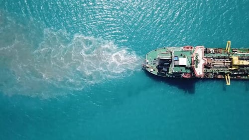 Trailing Suction Hopper-Dredger ship roaring across the sea