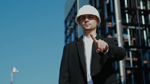Young Architect Gestures Towards Modern Building and Sky