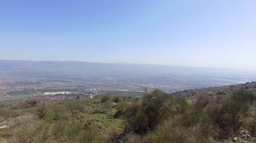 vale enorme com uma cidade no fundo exposta e a montanha Hermon ao fundo