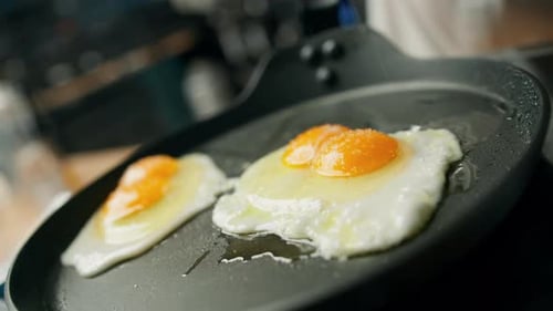Cooking Fried Eggs in Pan with Seasoning