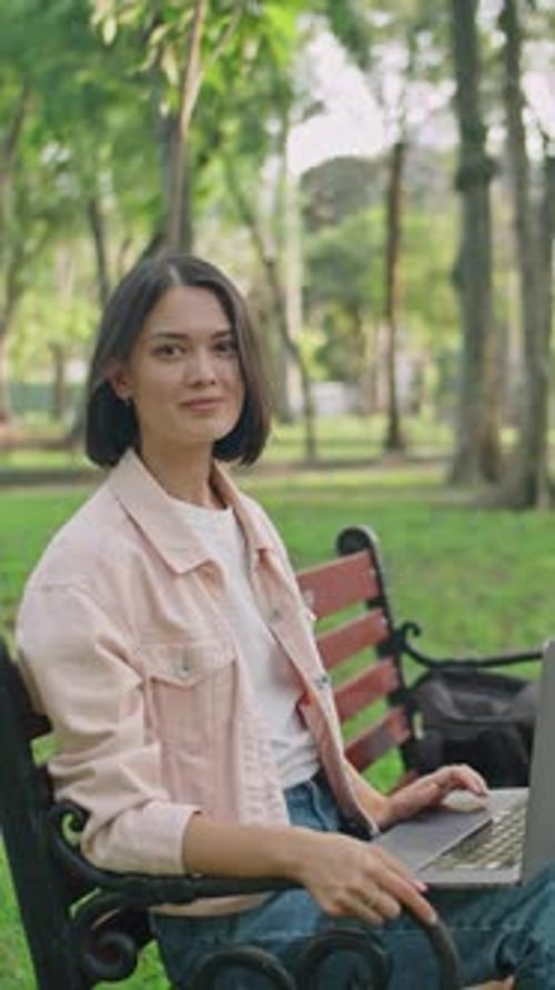 Portrait of Young Happy Woman with Laptop in Park