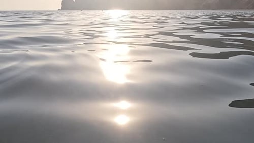 Meereswasseroberfläche, niedriger Winkel, Blick über klares azurblaues Meerwasser, Sonnenblendung, abstrakter nautischer Sommerozean