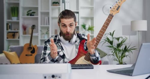 Man Talks With Electric Guitar in Home Studio