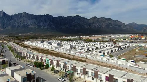 Aerial View of Modern Housing Complex Nestled Against Rugged Mountains