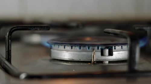 Close Up View of Old Gas Stove Fire Starts to Burn and Kettle or Pot is Placed on Burner