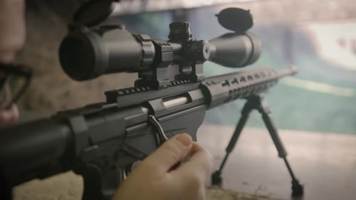 Shooter reloading sniper rifle at shooting range, close up on weapon