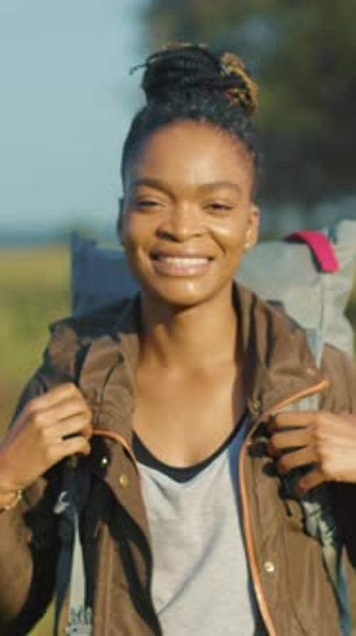 Un voyageur confiant ajuste ses bretelles et un routard souriant sur le terrain face au lever du soleil