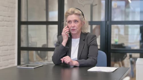 Senior Old Business Woman Talking on phone in Office