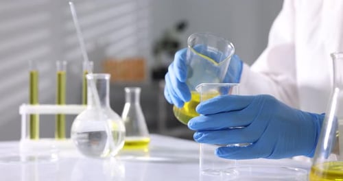Scientifique vérifiant la qualité de l'huile moteur à une table en laboratoire, gros plan