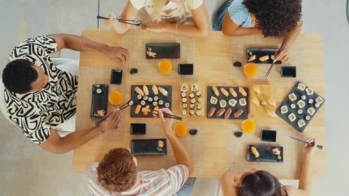 Group of friends eating sushi together at home.