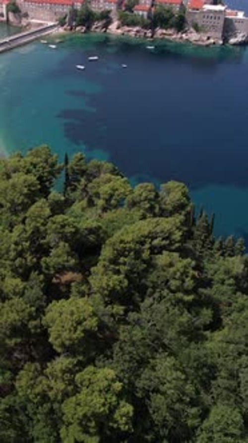 Sveti Stefan, Montenegro. Vertical Drone Shot of Small Island Resort, Beach and Adriatic Sea Horizon