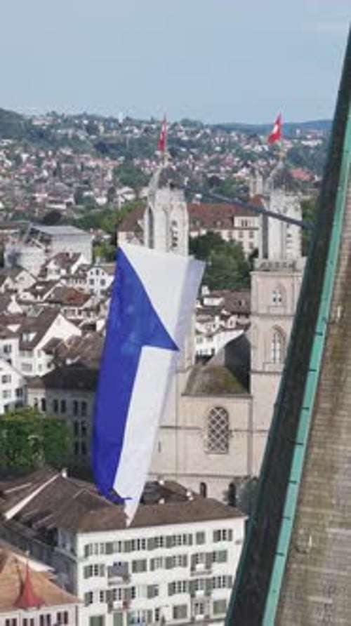 Aerial video of the Swiss flag at the Grossmunster church and the city in the background.