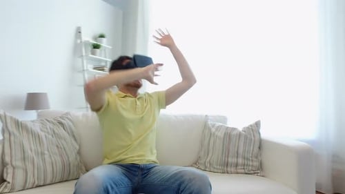 Man on sofa experiencing virtual reality with headset
