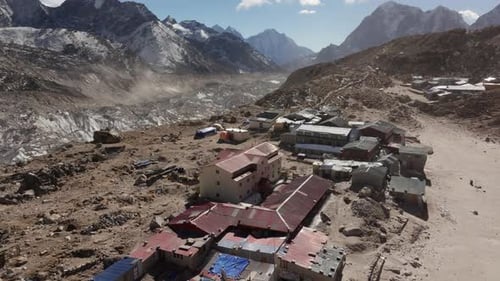 Skyward View of a Secluded Mountain Village in Nepal Highlighting Rustic Architecture and a Towering