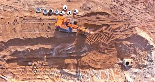 Auf einer Baustelle gräbt ein Bagger einen Graben, um Abwasserleitungen zu verlegen und anzuschließen