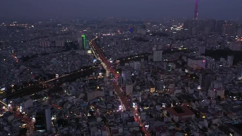Ho Chi Minh City Vietnam evening featuring key buildings of skyline and Saigon river under lights.