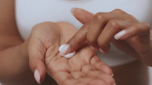 Woman Testing Cosmetic Cream on Palm Close Up