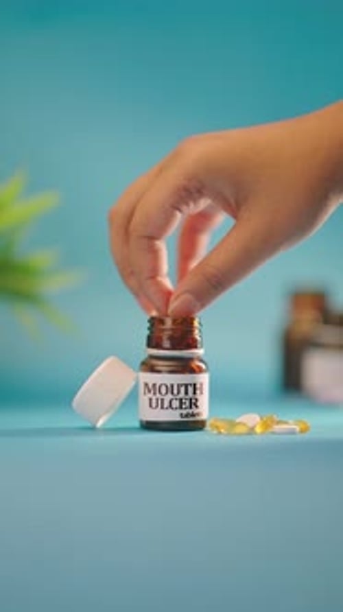 VERTIKALES VIDEO, IN DEM DIE HAND MUNDGESCHWÜRTABLETTEN AUS DER MEDIKAMENTENFLASCHE HERAUSNIMMT