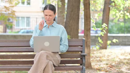 Woman With Headache Working on Laptop in Park