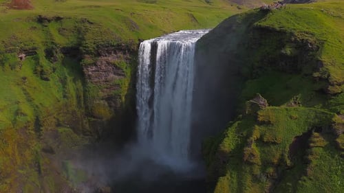 Aerial View of Skogafoss Waterfall with Lush Green Cliffs in Iceland