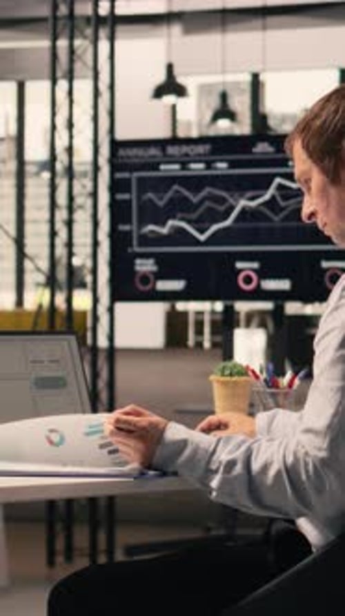 Vertical Video Male Office Worker Solving Tasks Independently on Laptop at Desk