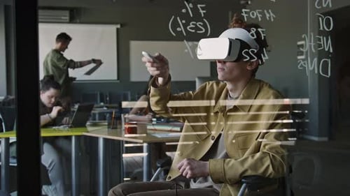 Man in Wheelchair Testing Augmented Reality App with VR Headset in Office