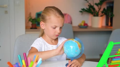 Hausunterricht für Kinder, Mädchen zeigen Land auf der Welt. Das Schulmädchen studiert den Globus
.