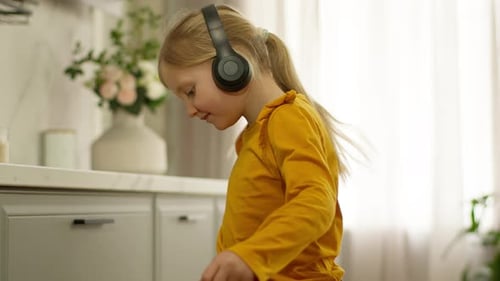 Caucasian Little Girl Child Kid Daughter in Headphones Listen Music Songs Dancing Listen Melody
