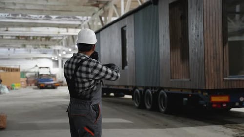 Construction Worker Directing Modular Home Transportation Process