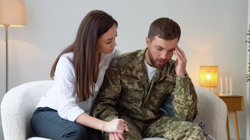 Depressed Soldier Talking to Therapist While They Sitting on Sofa During Therapy at Office