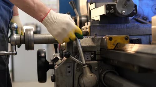 Man Operates Metal Lathe in Workshop