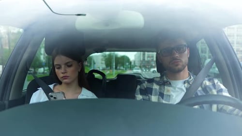 Casal dirigindo um carro e apertando cintos de segurança, jovem usando smartphone, transporte, viagem