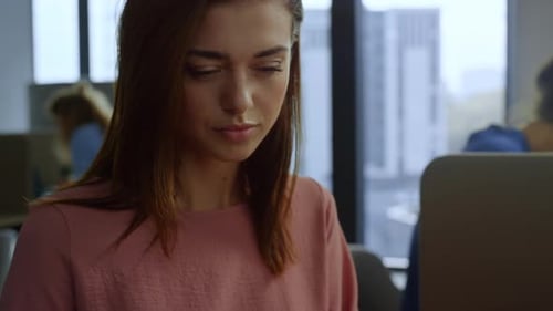 Businesswoman Analyzing Charts and Typing at Desk