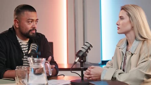 Man and Woman Speaking into Microphones in Studio