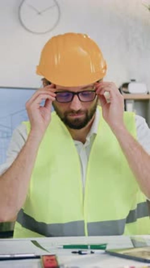 Architect Hard Hat Drawing Plans at Desk Portrait