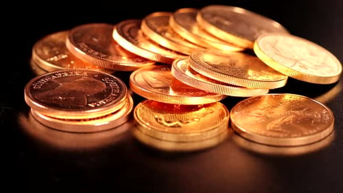 different gold coins lie unsorted next to each other