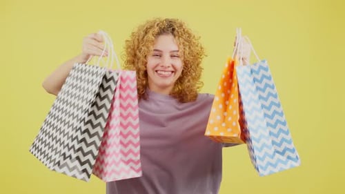Smiling Woman Holding Colorful Shopping Bags