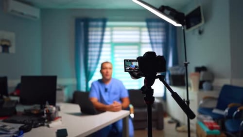 Man in Scrubs Recording Video in Medical Office