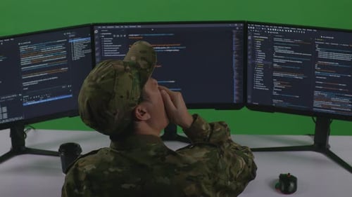 Tired Asian Man Soldier Yawning While Write Code With Multiple Computer Screens In Green Screen