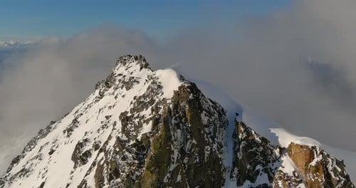 Snowy Mountain Peak Above The Clouds. British Columbia, Canada.