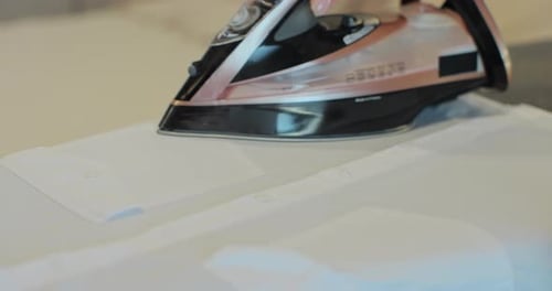 Close Up of Woman Ironing Clothes on Ironing Board Home Routine Housekeeping