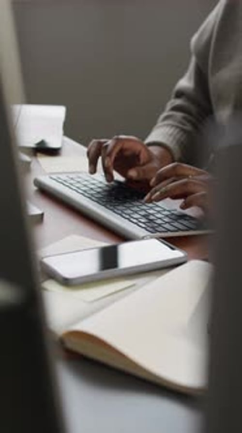 Hands of Unrecognizable Office Worker Typing on Keyboard at Desk