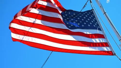 Waving American Flag Against Blue Sky Background