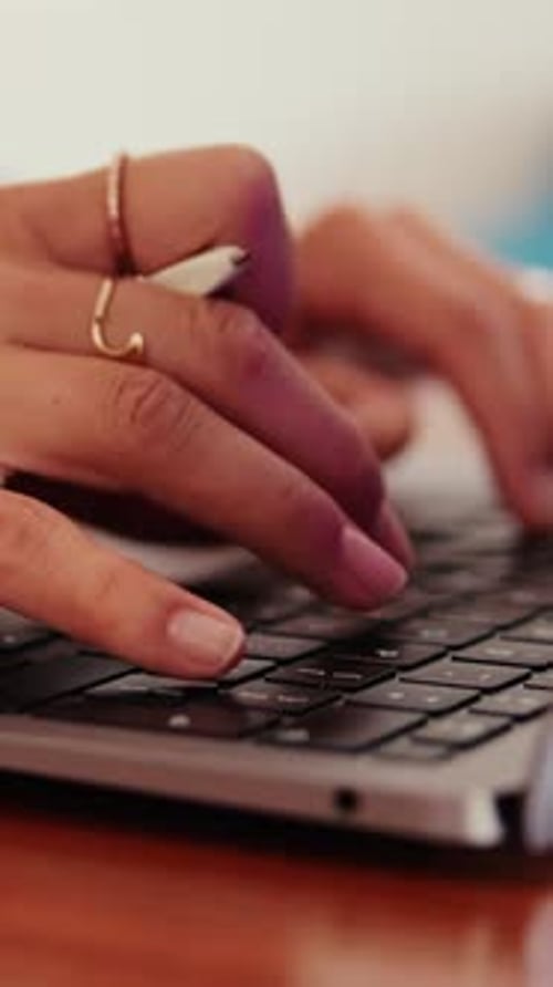 Vertical video, Close-up of hands of woman typing on computer keyboard at desk in home office