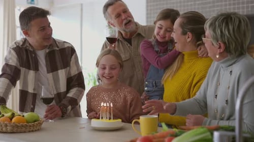 Família extensa comemorando aniversário com bolo e velas