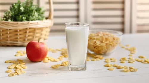 Glass of Milk and Corn Flakes on Table