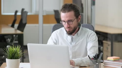 Man Working at Computer Massages Stiff Neck