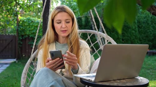 Frau mittleren Alters arbeitet aus der Ferne auf der Terrasse